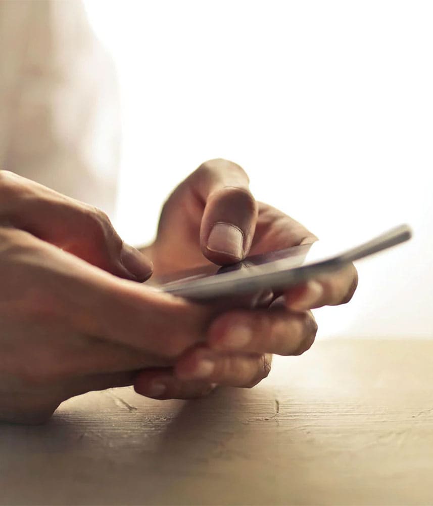 Personne utilisant un smartphone avec les deux mains