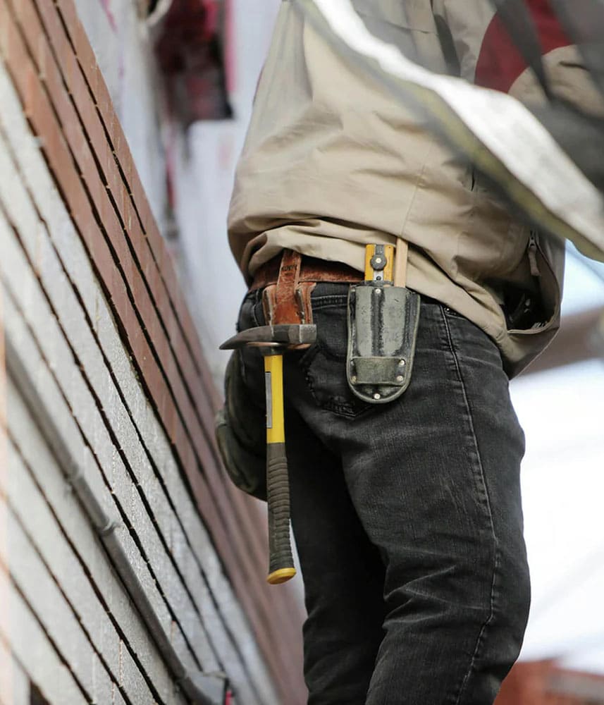 Ouvrier sur un chantier, marteau et outil