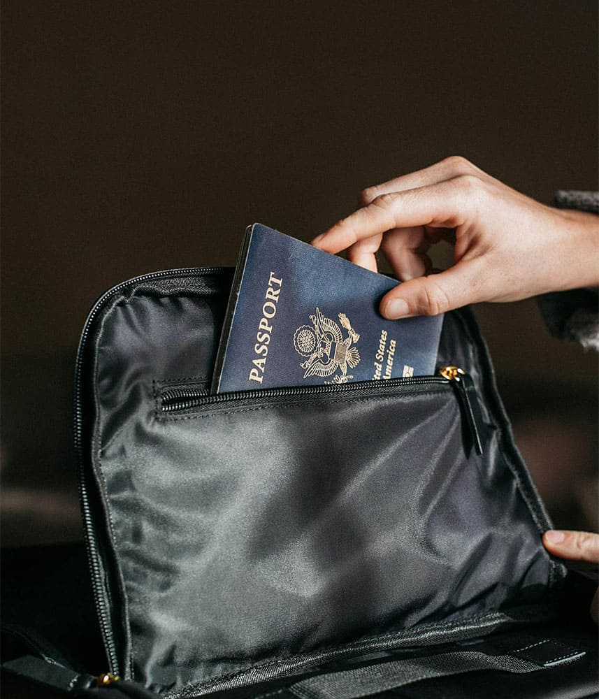 Personne rangeant un passeport américain dans un sac