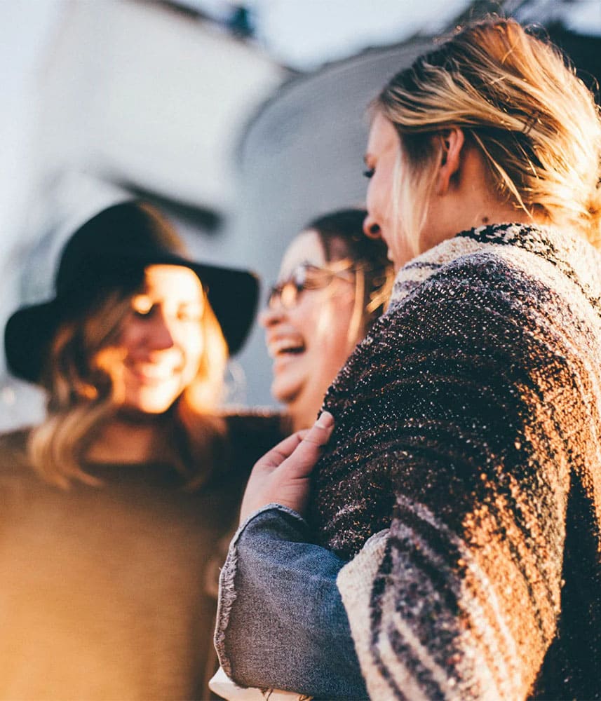 Trois amies souriantes partageant un moment de joie
