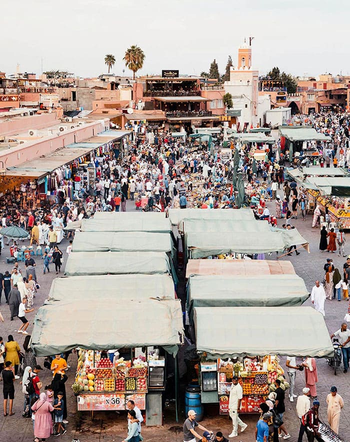 Marché animé avec stands couverts et foule nombreuse